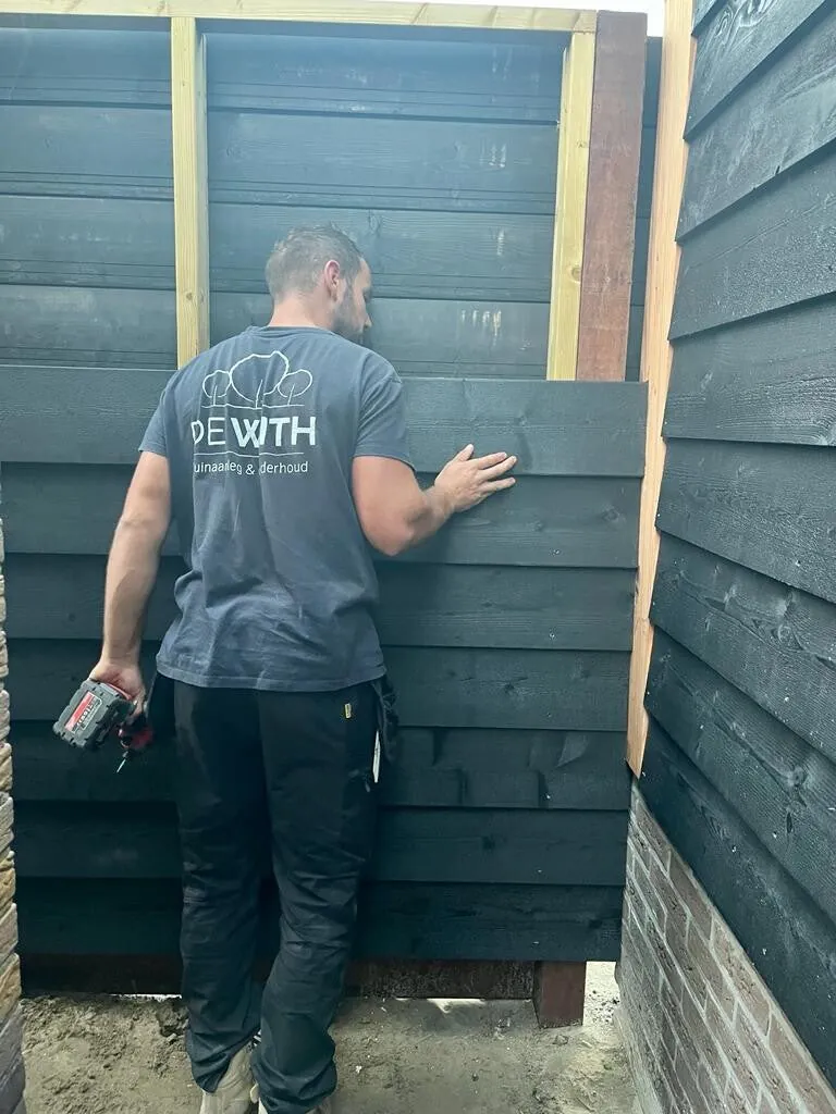 Robin de With aan het werk aan een zwart gepotdekselde tuinkamer